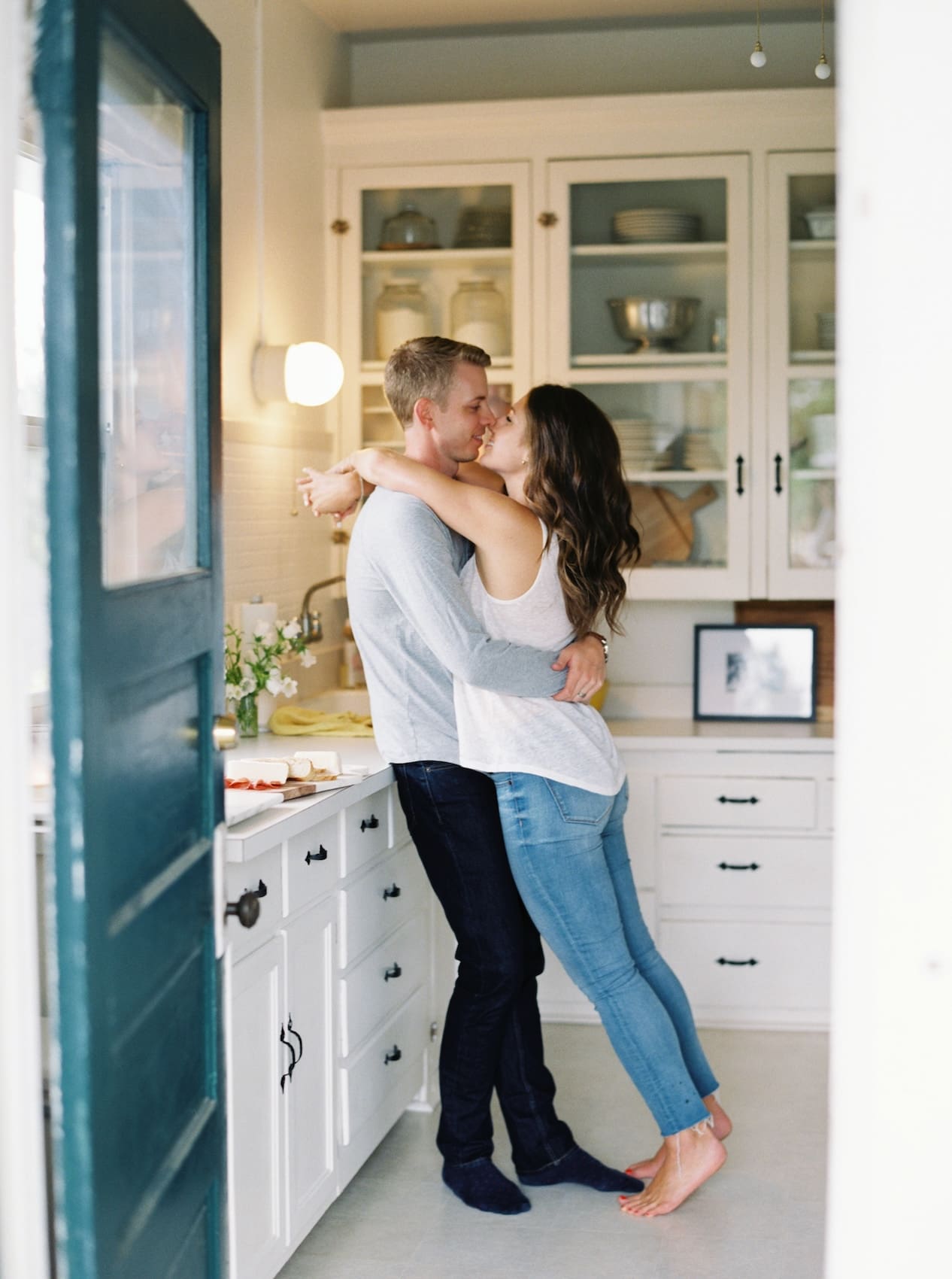 Couple embracing in a cozy kitchen setting with warm tones