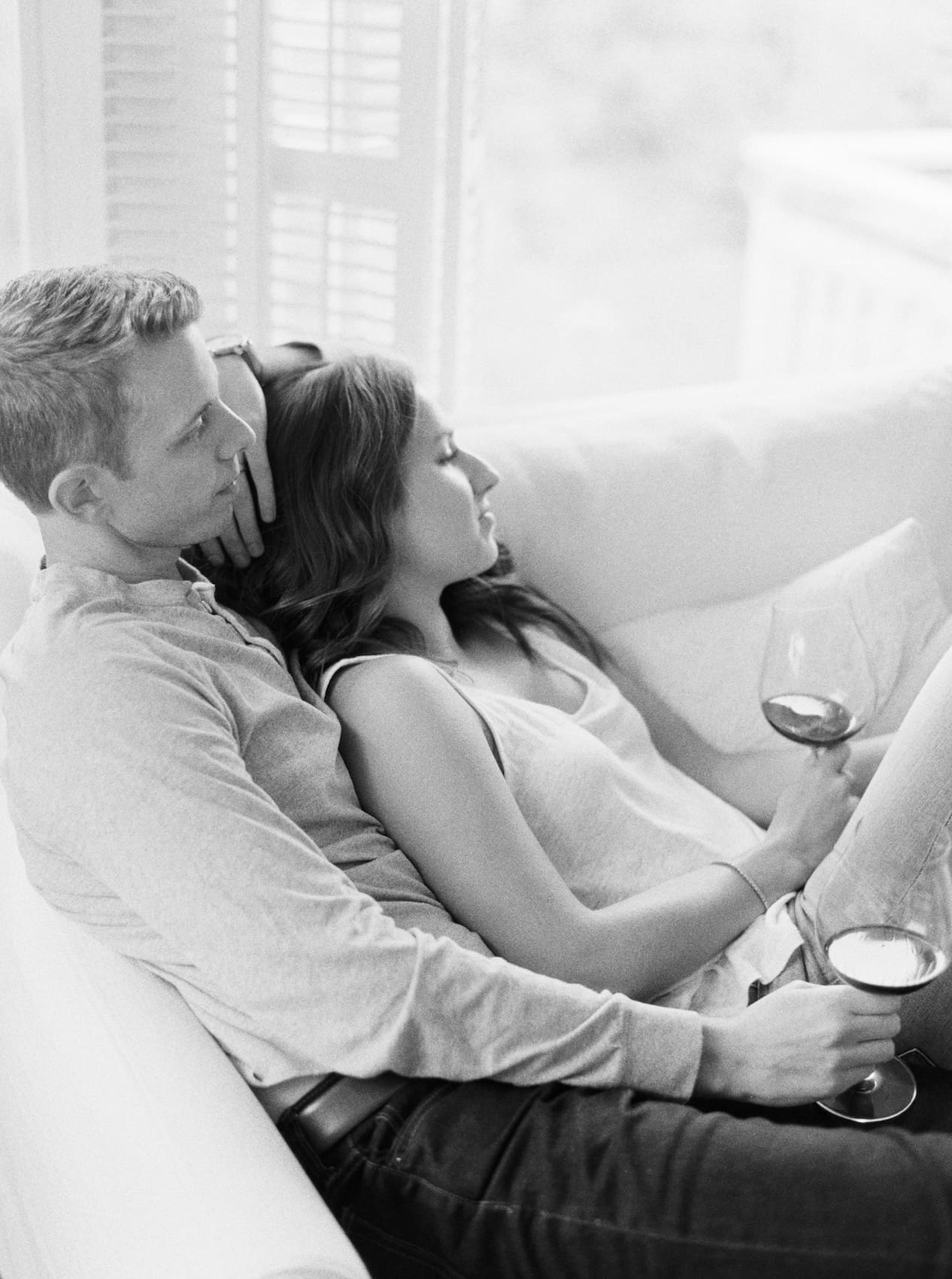 Couple relaxing on sofa with wine glasses in cozy living room