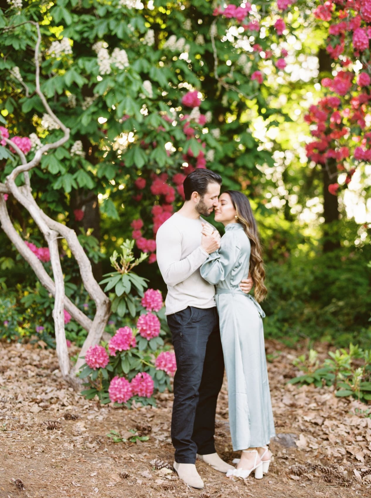Couple embracing in a lush garden with blooming flowers