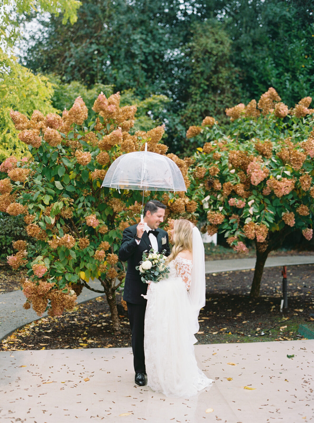 bride and groom with umbrellas at fox hollow farm wedding