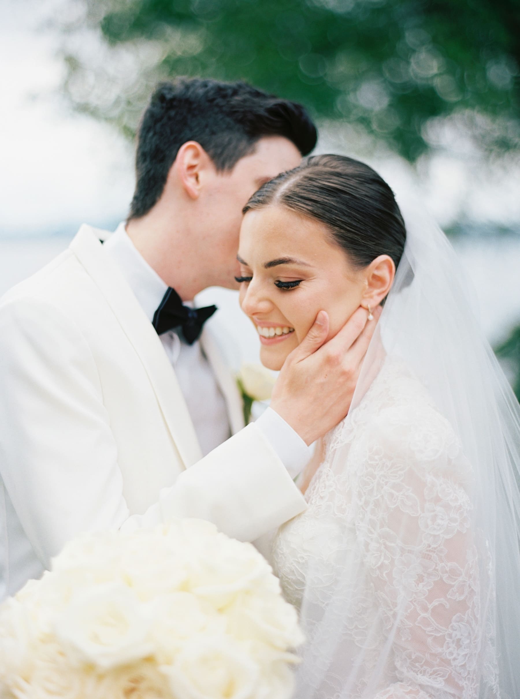 groom whispering in brides ear at woodmark hotel wedding photography shoot