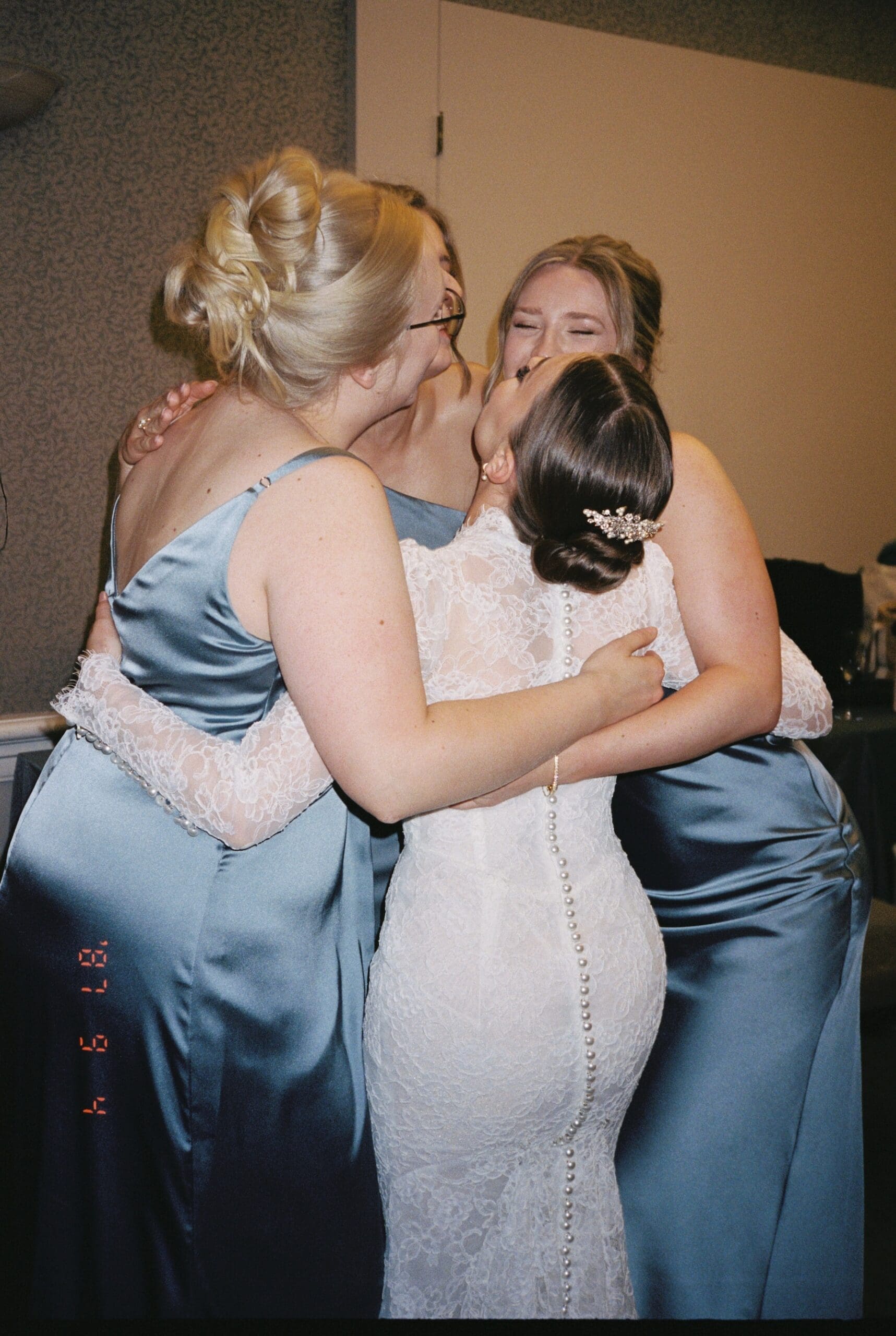 bride and bridesmaids hug excitedly captured on film on point and shoot camera with flash