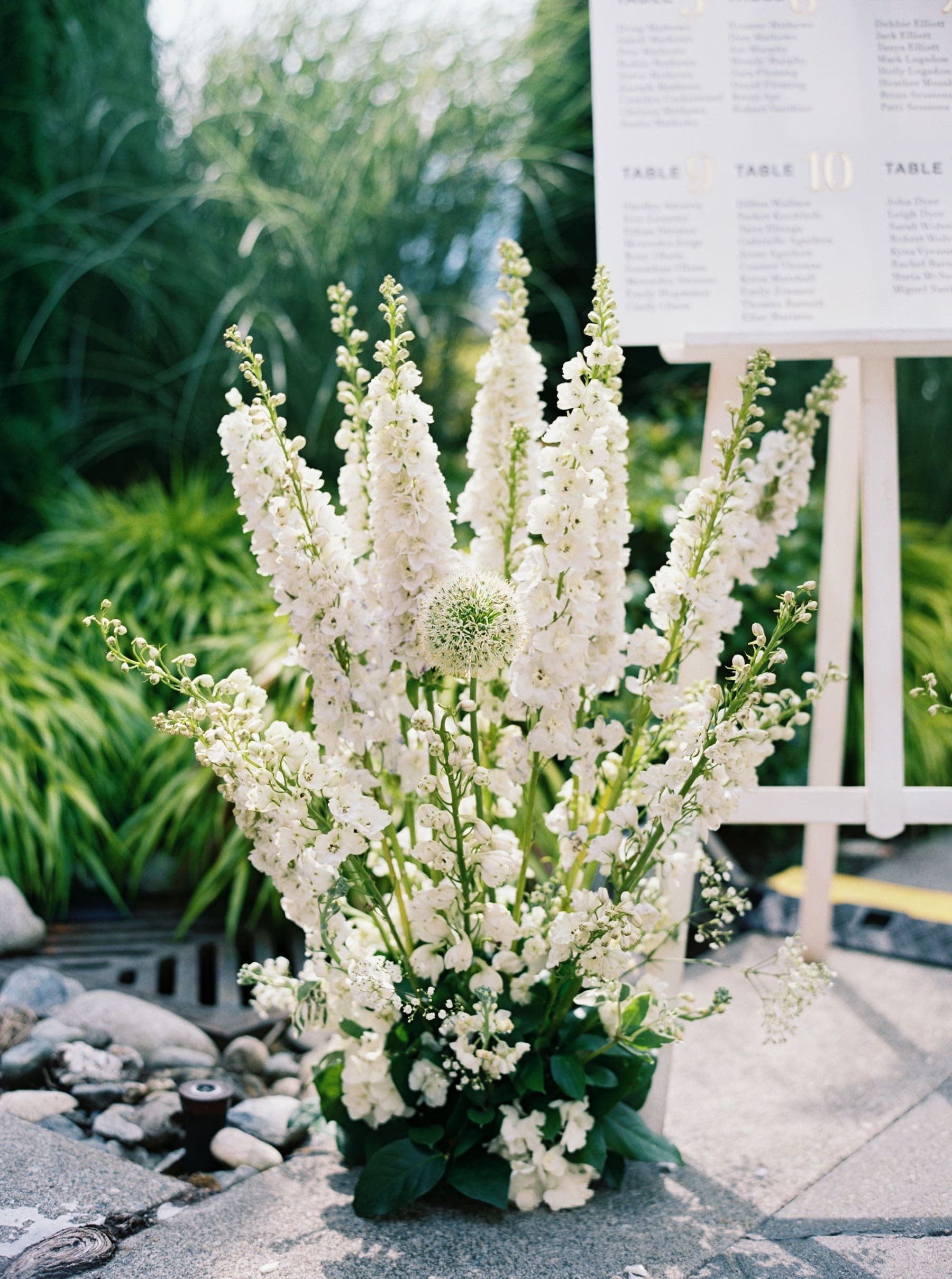 White floral arrangement in garden setting with greenery