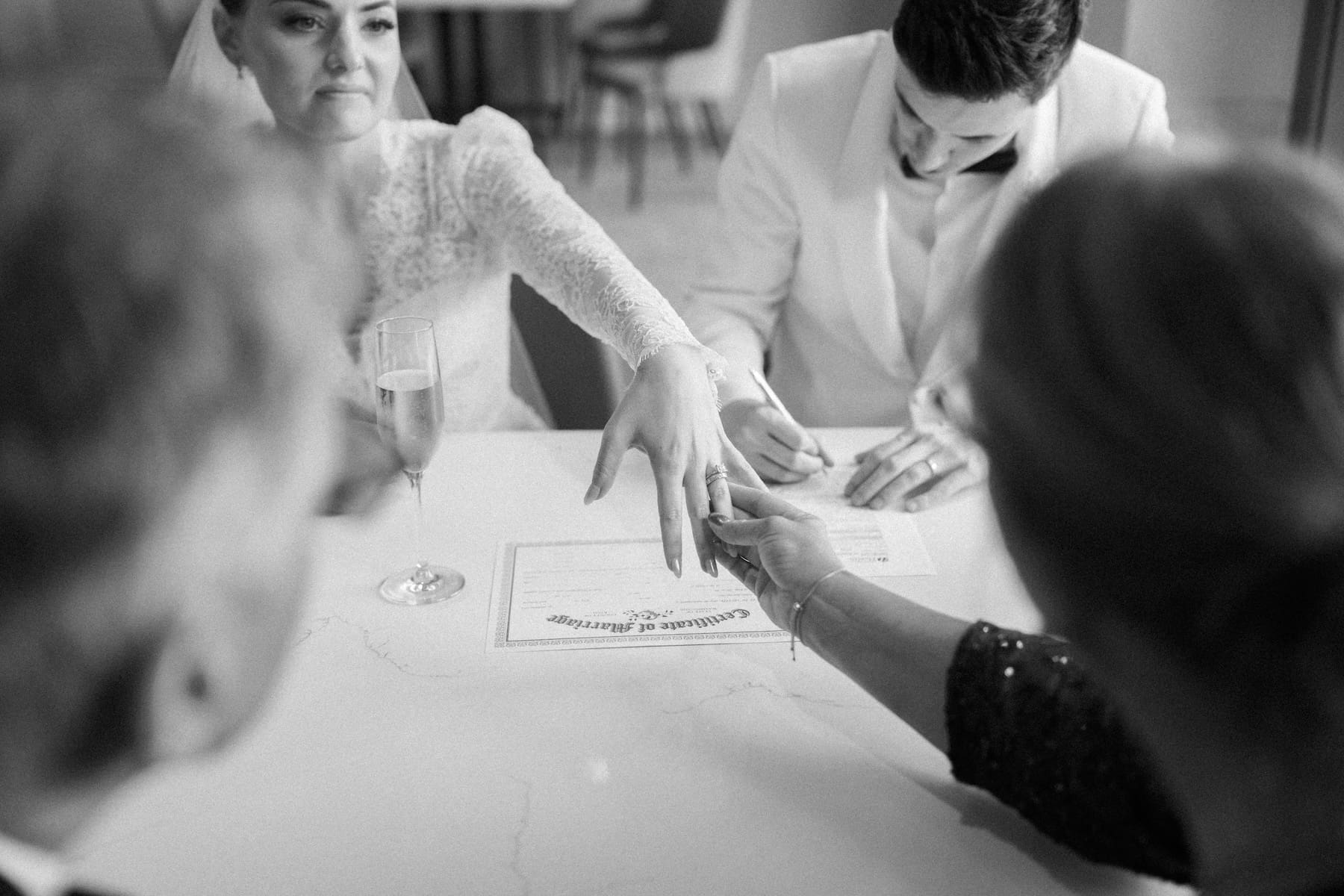 Bride and groom signing wedding certificate with witnesses