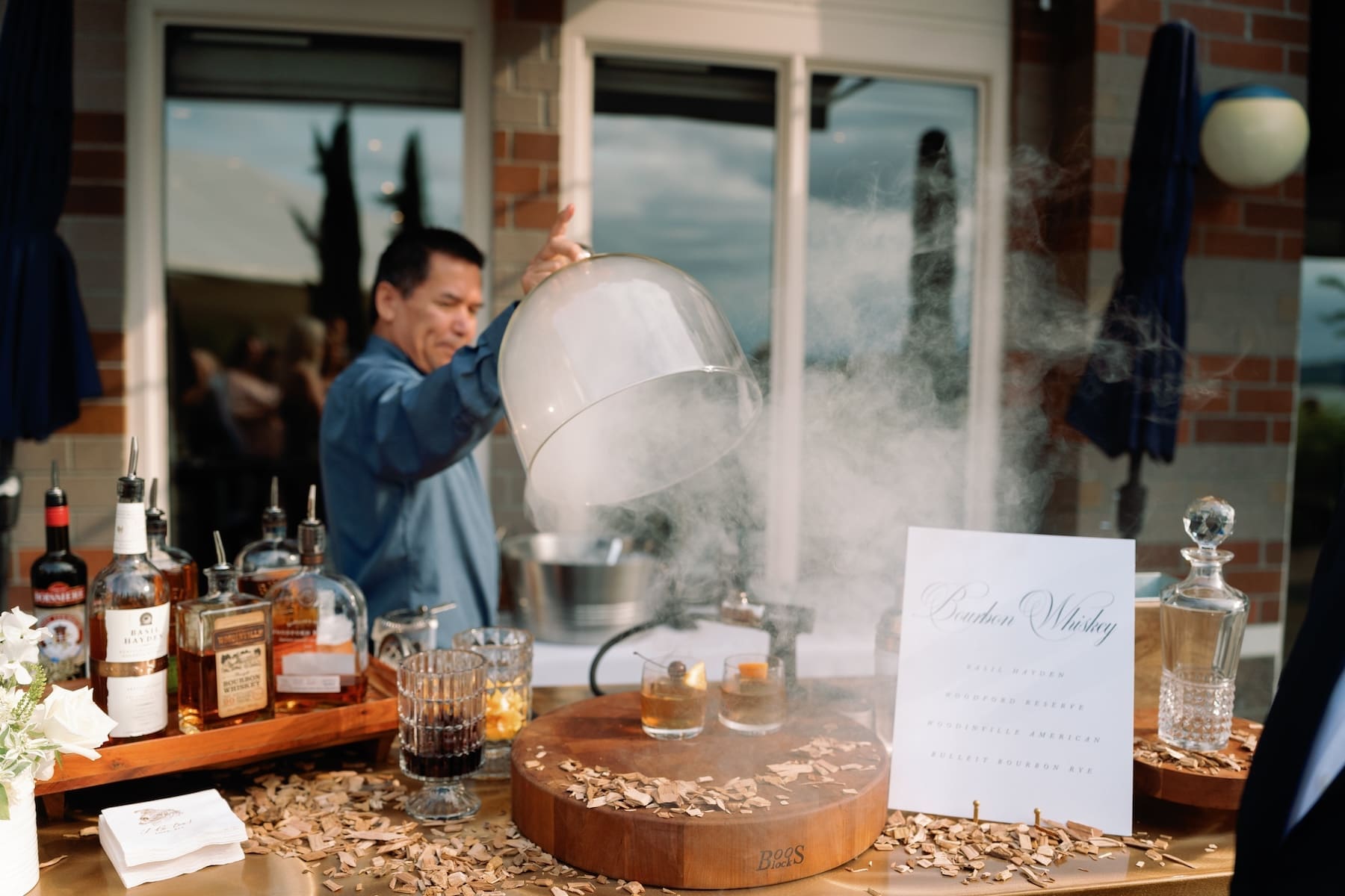 Man preparing drinks with smoke at an outdoor event