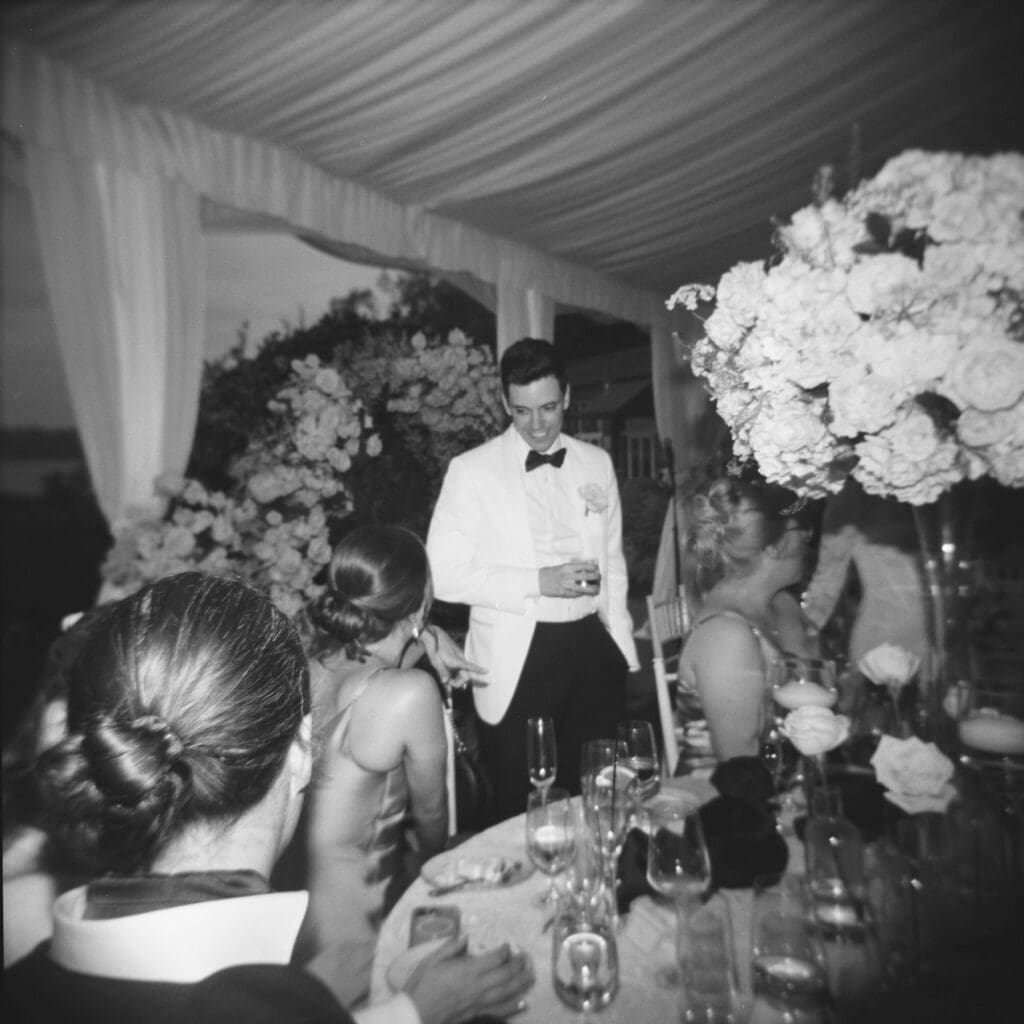 holga ilford delta 3200 black and white image of groom at wedding reception 