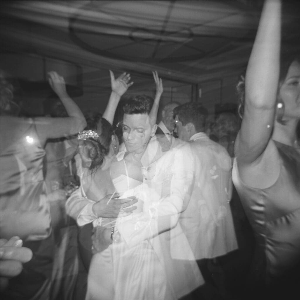 holga ilford delta 3200 black and white image of bride and groom dancing indoors in the dark
