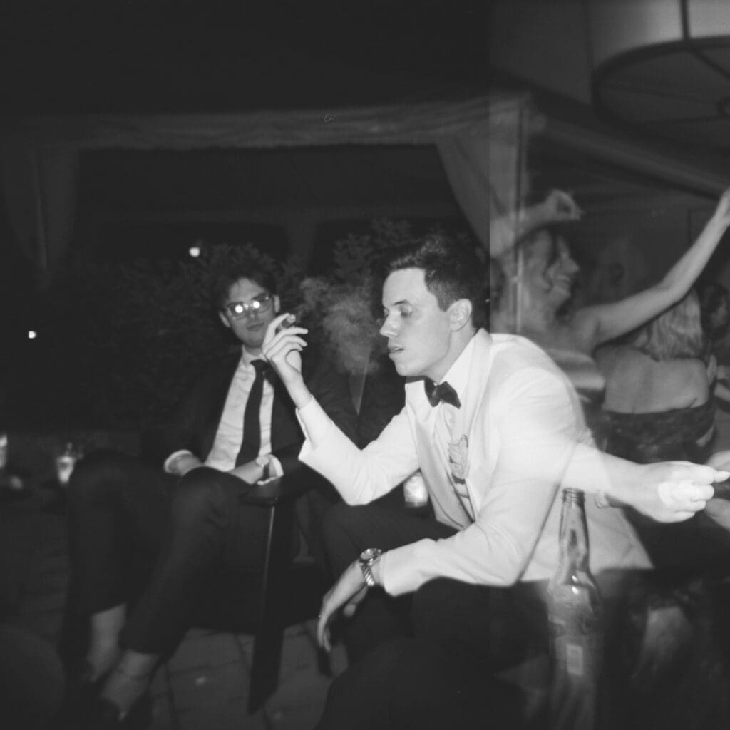 holga ilford delta 3200 black and white image of groom smoking cigar