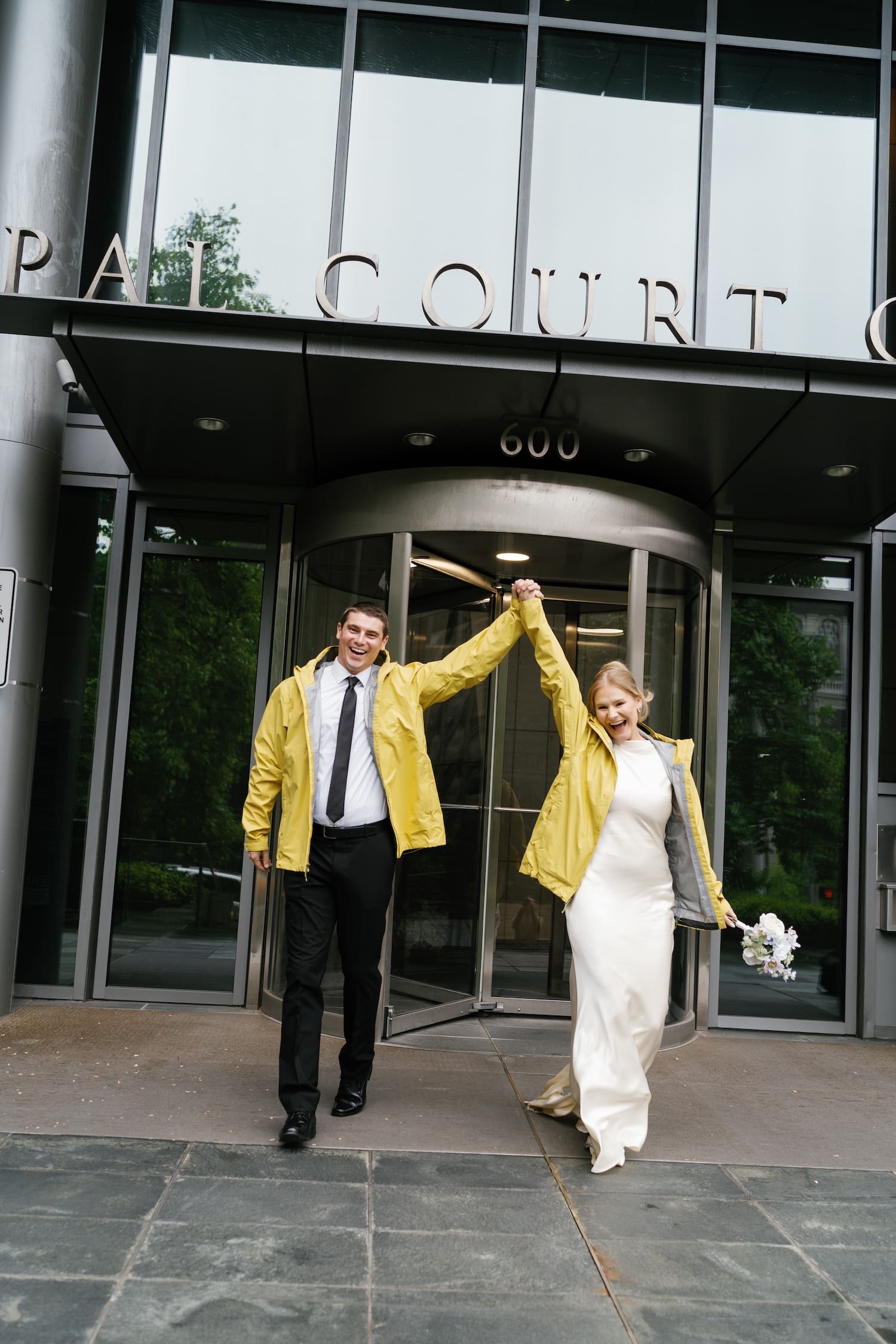 bride and groom running out of the door at the seattle municipal courthouse after their wedding elopement 