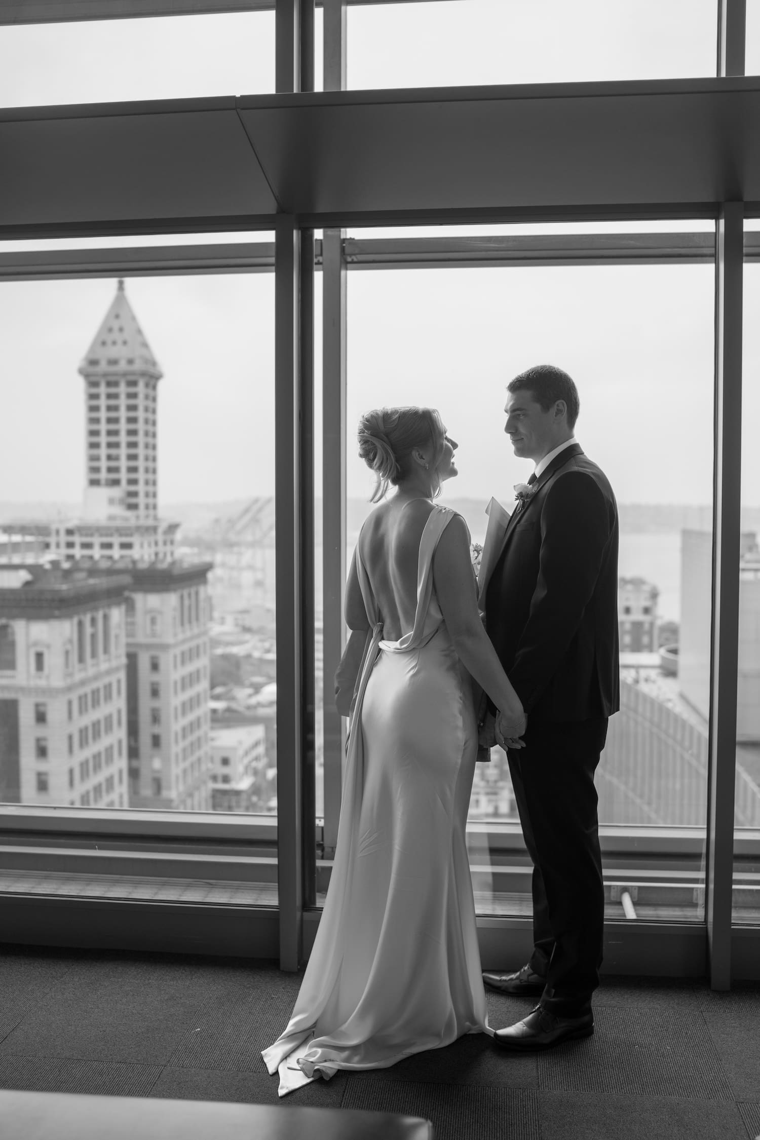 bride and groom photos of the couple waiting inside the seattle courthouse with smith tower in background